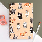 Notebook with watercolor kittens on a light peach background.
