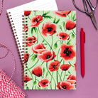 Notebook with red poppy flower illustrations on a light green background.