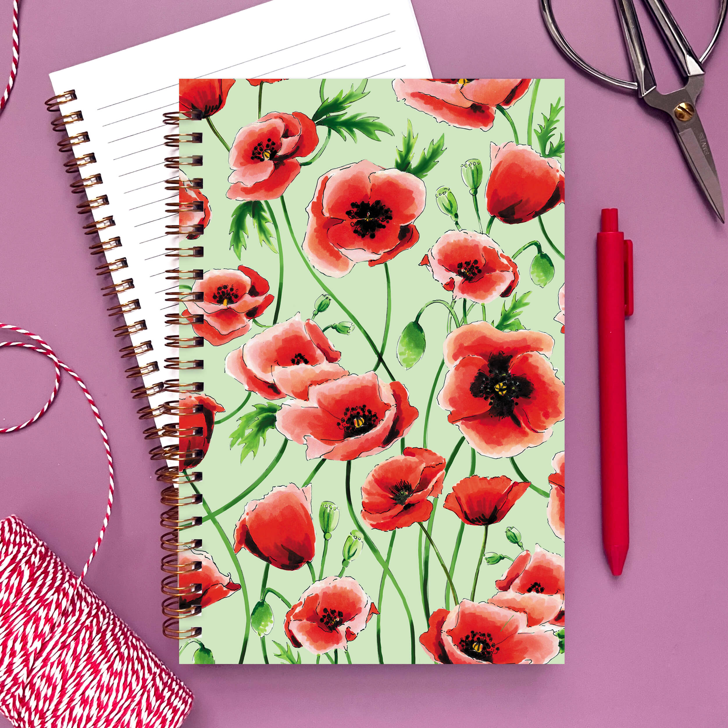 Notebook with red poppy flower illustrations on a light green background.