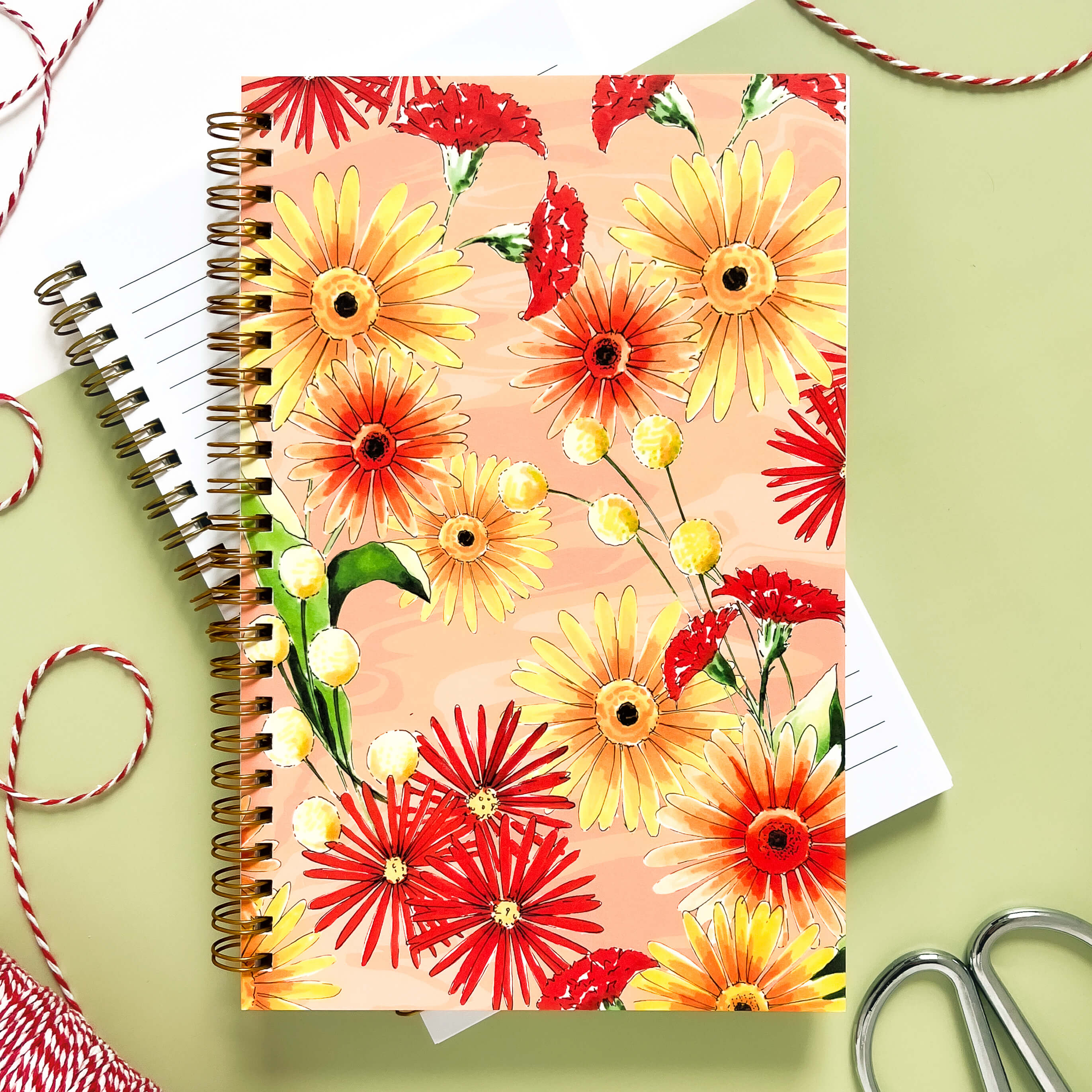 Notebook with yellow, red, and orange daisies and wildflowers.
