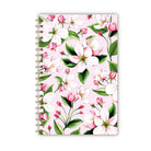 Notebook with pink apple blossom illustrations on a blush background.