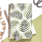 Notebook with watercolor green palm leaves on a light green background.