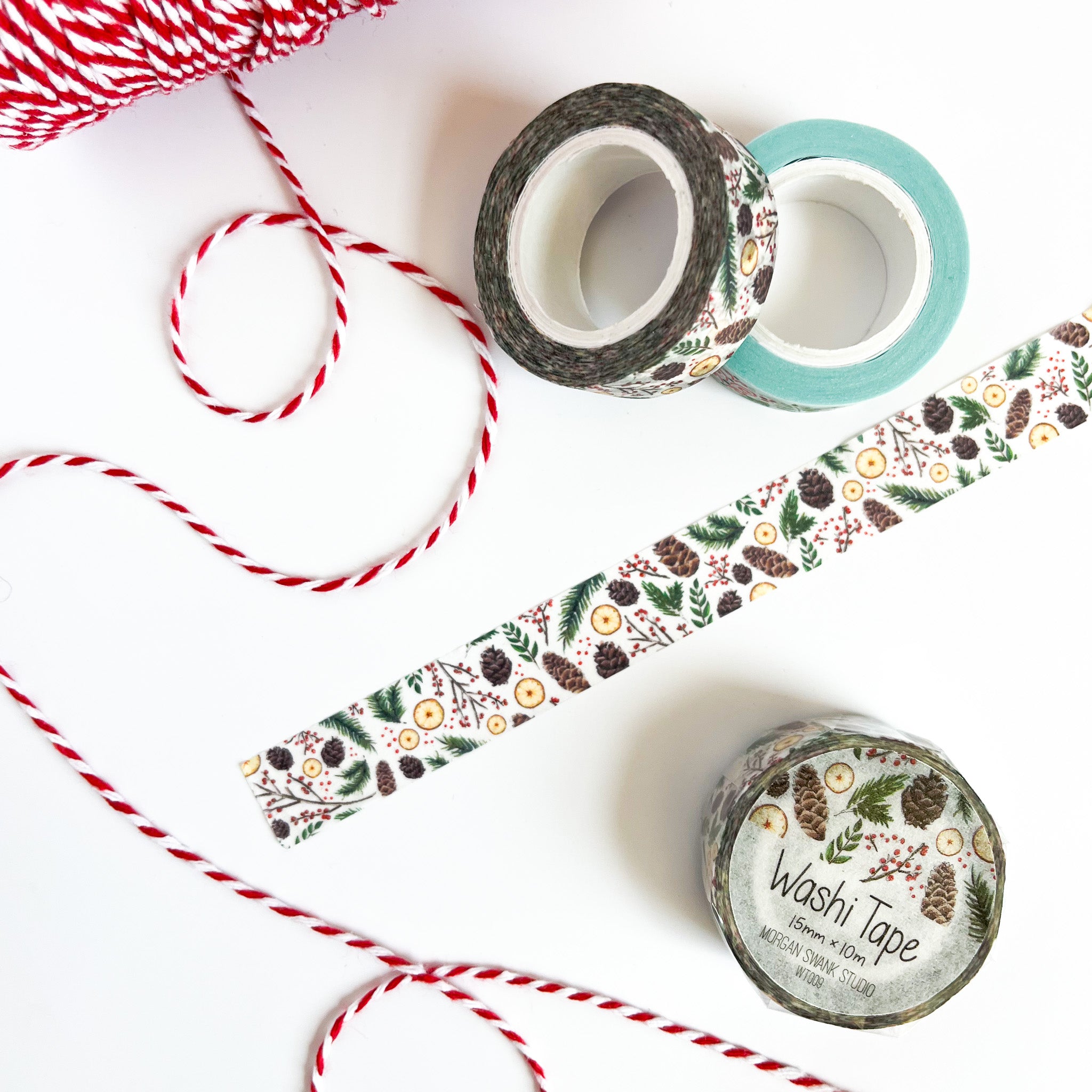 White washi tape with illustrations of pinecones, greenery, and orange slices