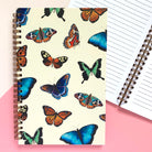 Notebook with colorful butterfly illustrations on a soft yellow background.