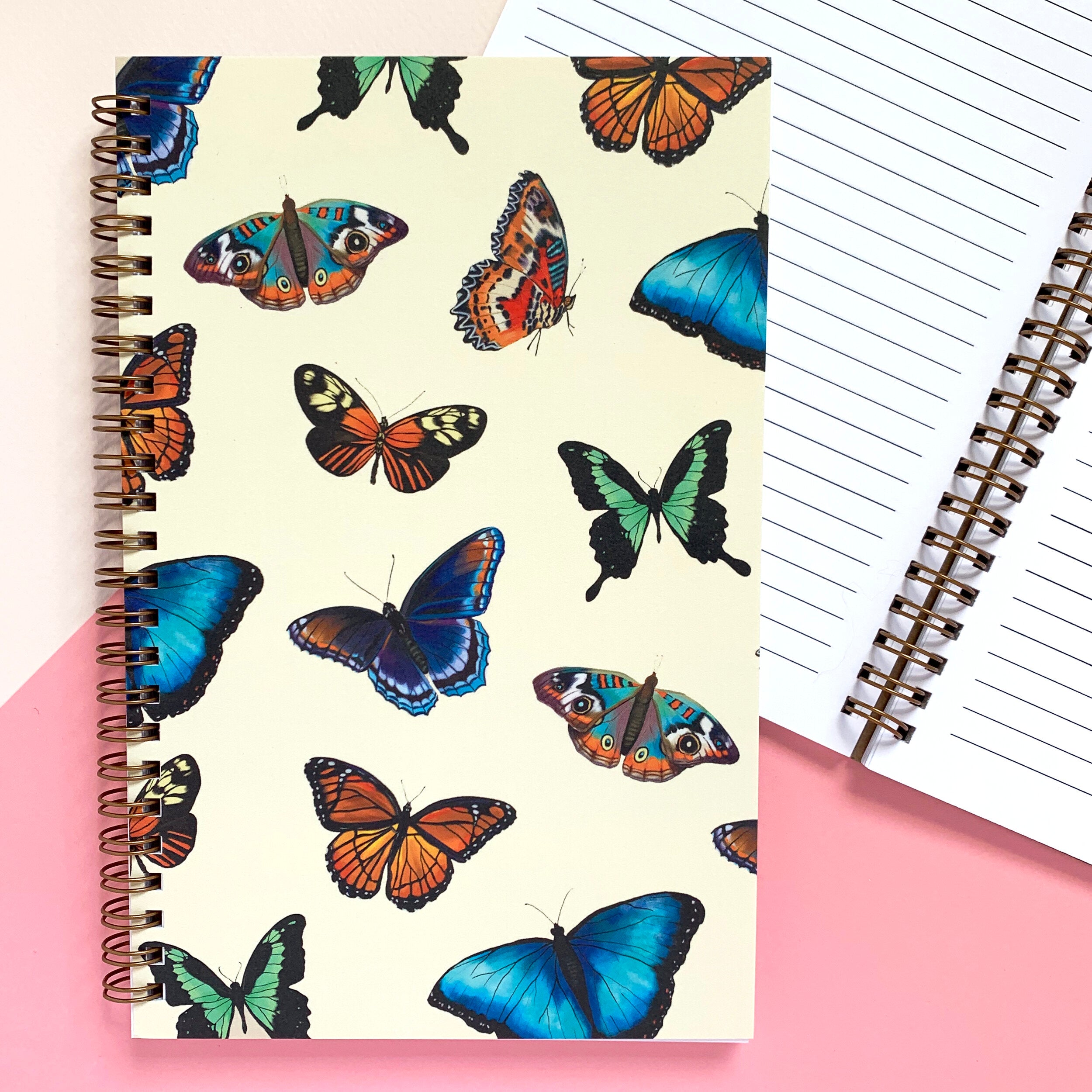 Notebook with colorful butterfly illustrations on a soft yellow background.