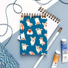 Eco-friendly mini notebook with illustrated corgis on blue background
