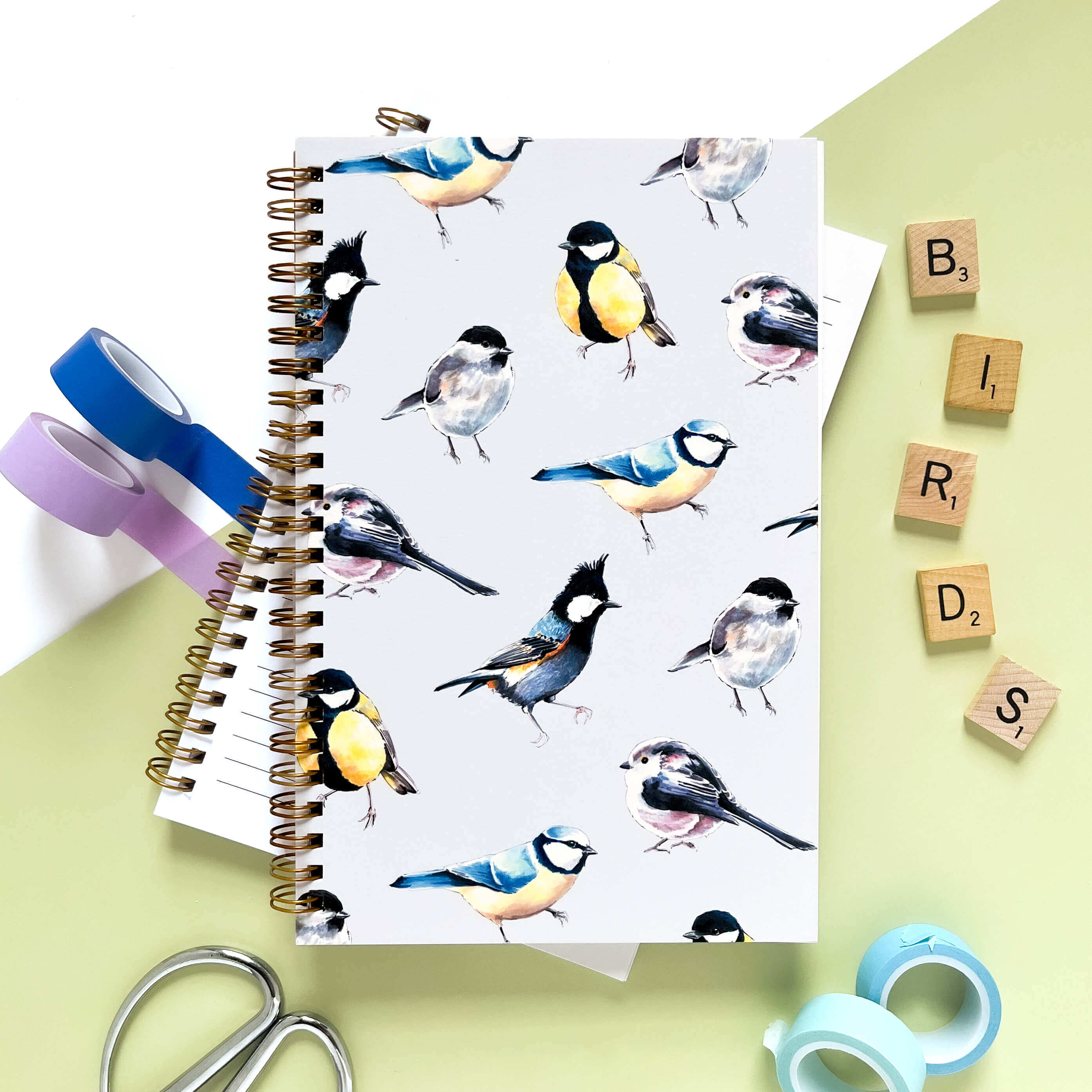Notebook with bird illustrations on a pale blue background.